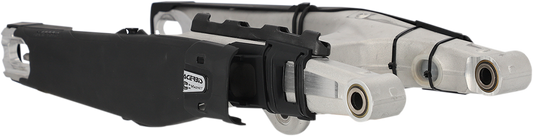 A black Acerbis Swing Arm Guard mounted on a motorcycle body, designed to protect the swing arm from debris and damage.