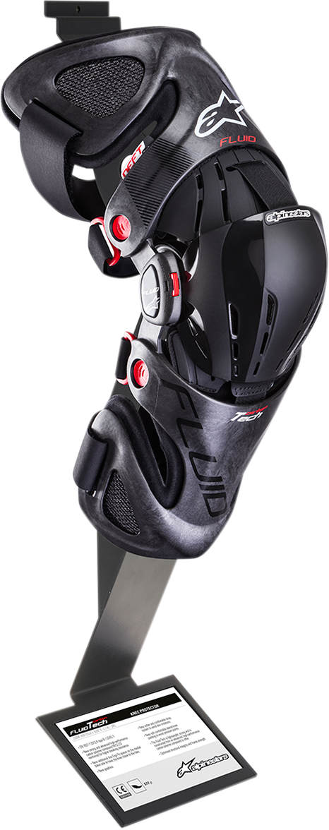 Alpinestars Fluid knee brace for motorcycle protection, shown in black with adjustable straps and protective padding.