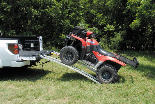 QuadBoss arched pair ramps for powersports vehicles, measuring 12x89 inches, shown in a natural outdoor setting.