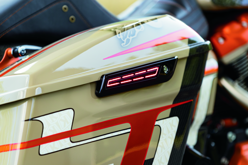 Kuryakyn LED saddlebag hinge accents on a Harley Davidson bike, featuring bright red run, brake, and turn signal lights.