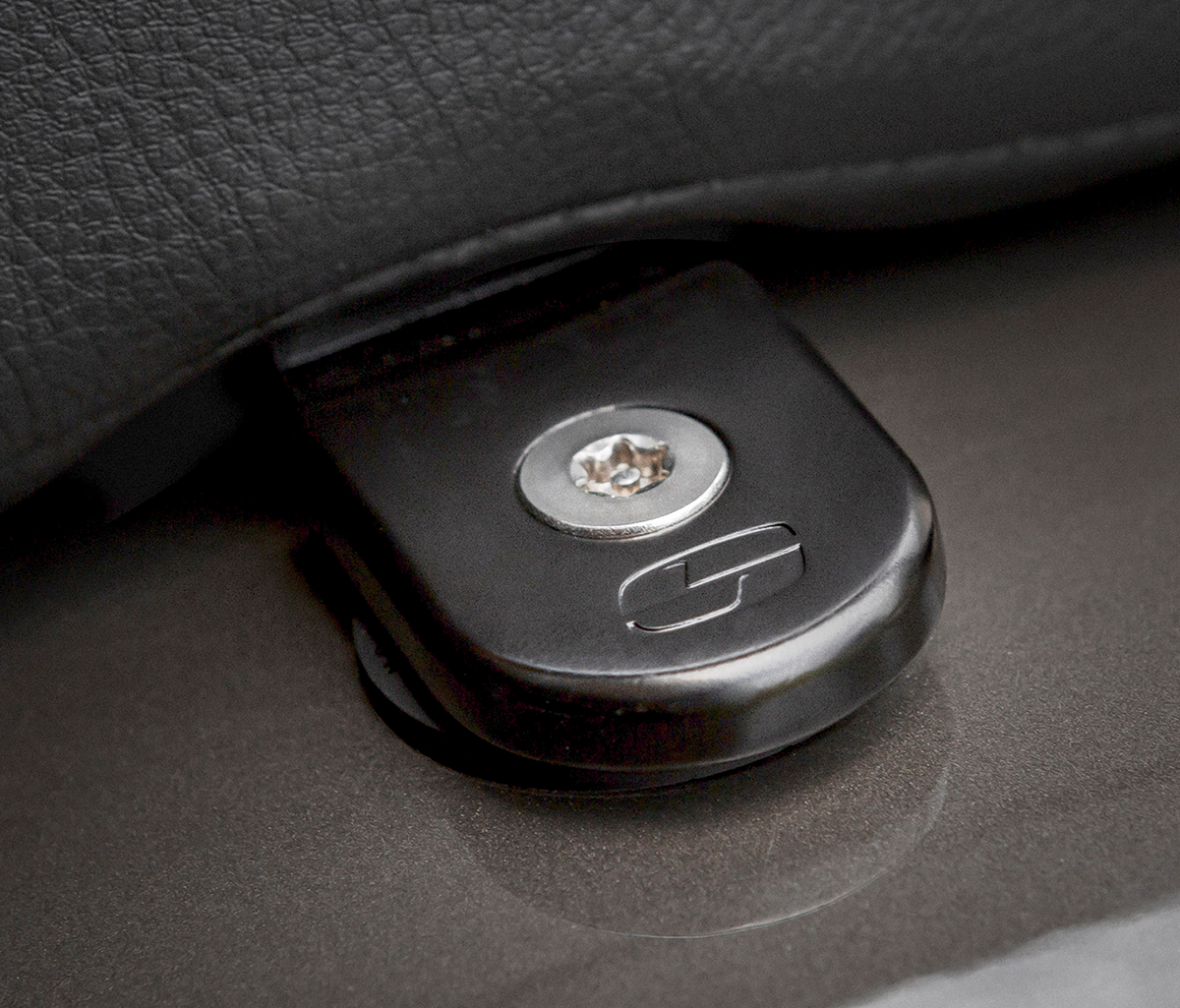 Black Saddlemens Security Seat Screw for motorcycle seats, designed for secure fastening and durability.