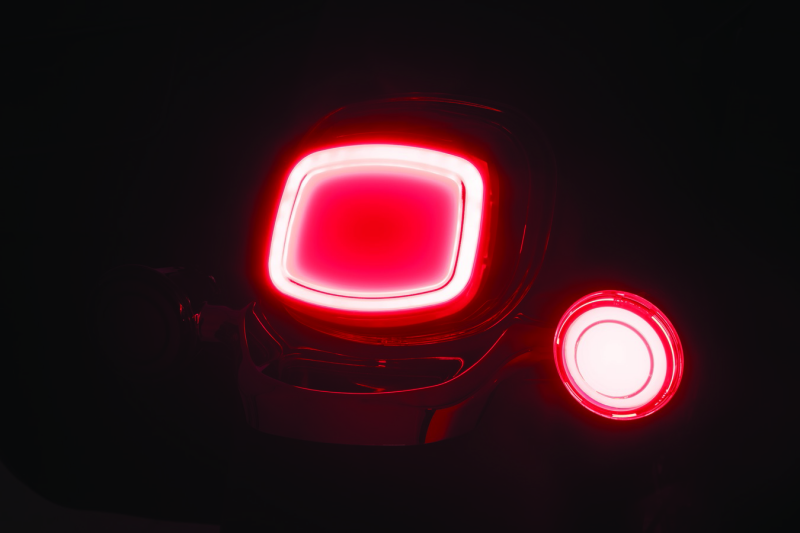 Kuryakyn Tracer LED front turn signal insert for Harley Davidson with red light and lens, part 2908, mounted on motorcycle.
