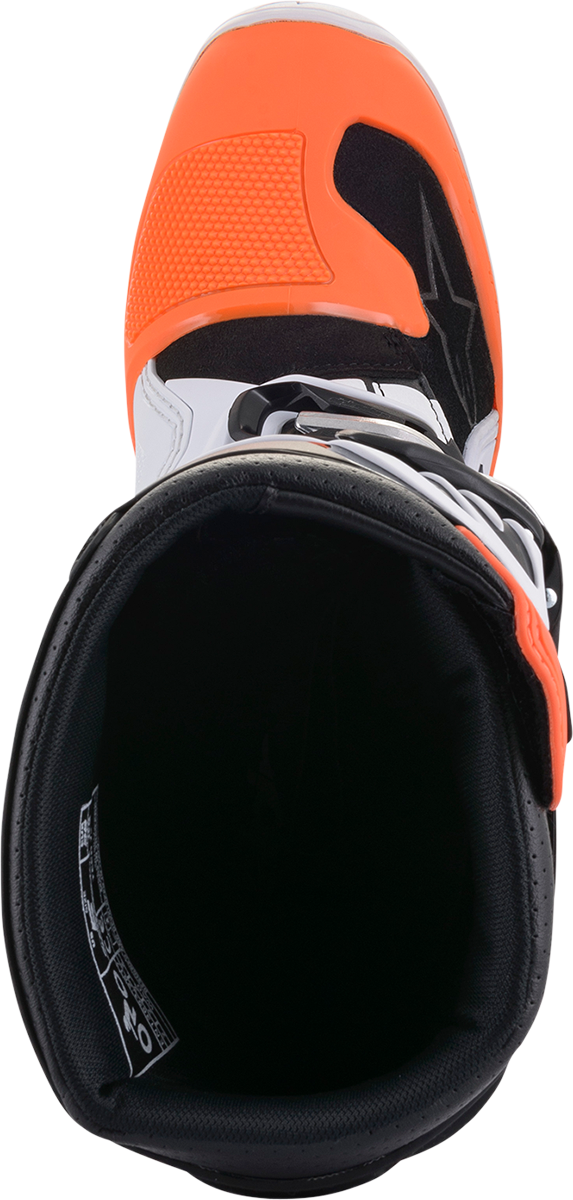 Alpinestars Youth Tech 7S motorcycle boots in black, orange, and white with adjustable straps and protective features.