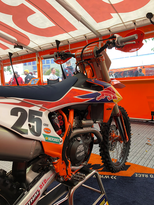 A close-up of Acerbis X-Grip frame guards in orange and black for motorcycle body protection, designed for durable fit.