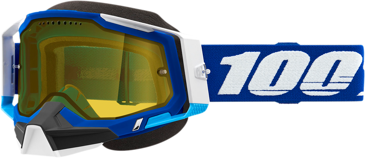 Blue and yellow 100% Racecraft 2 snow goggles with clear lenses and adjustable strap, designed for winter sports protection.