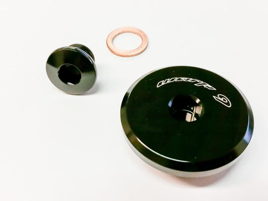 Black Suzuki DR650 engine plug by Warp9Racing, close-up view showing durable replacement part for engine maintenance.