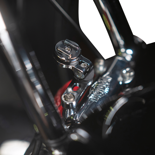 Chrome SP CONNECT Pro Phone Mount handlebar clamp attached to a motorcycle handlebar, securely holding a smartphone.