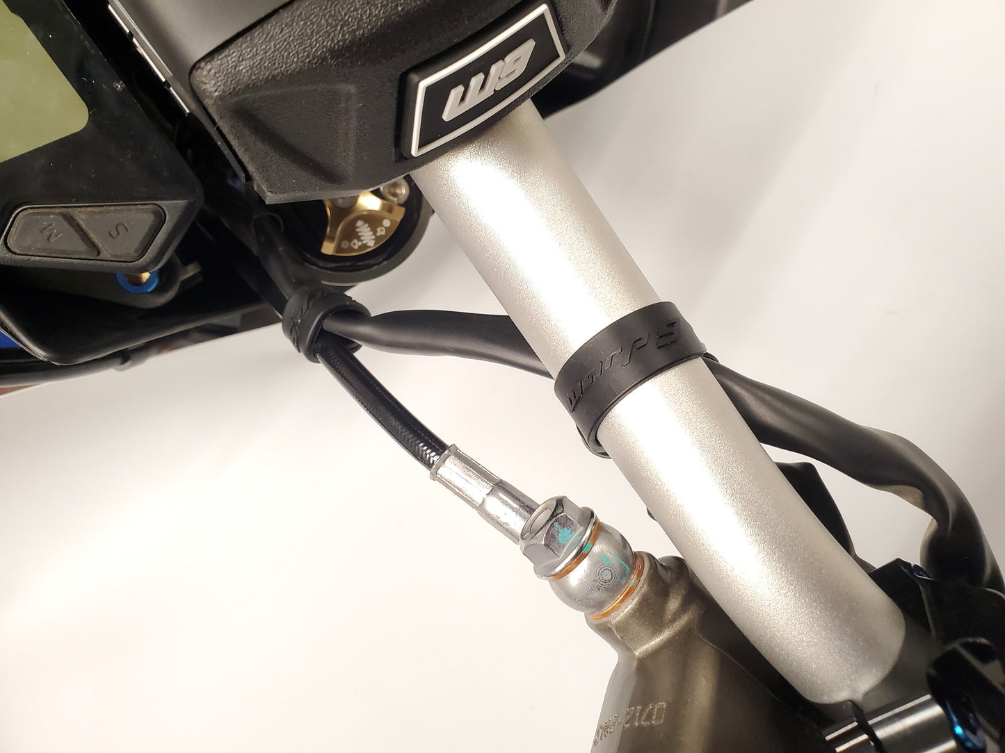 Warp9Racing Surron bar straps from Collective brand, showing durable black nylon straps with metal hardware for handlebar support.