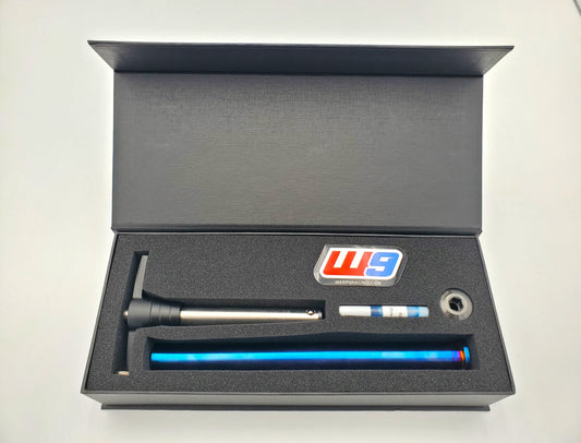 Titanium rear axle for Husqvarna motorcycle by Warp9Racing, shown in a boxed, scaled image with detailed features.