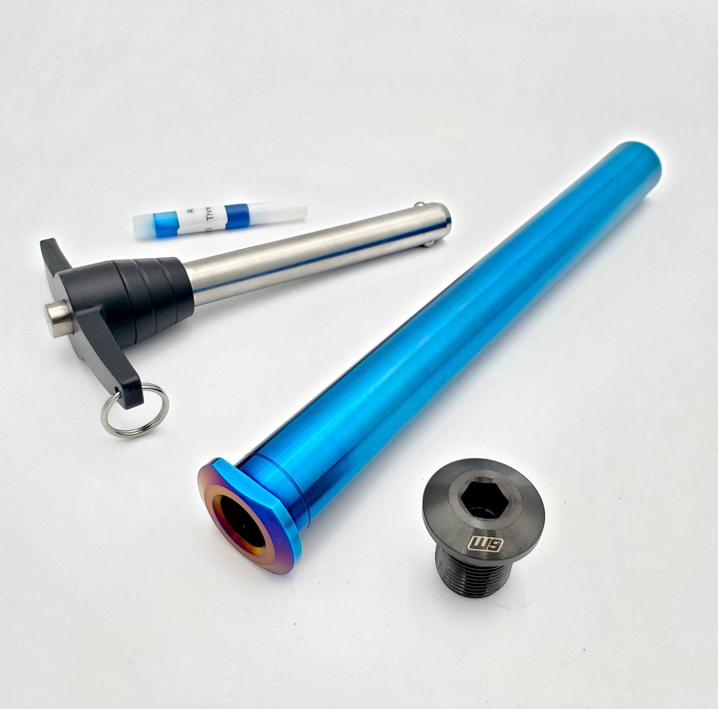 Titanium rear axle for Husqvarna motorcycle by Warp9Racing, showing a sleek, lightweight, precision-engineered component.
