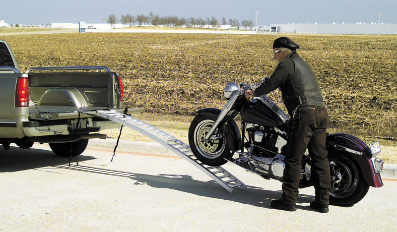 QuadBoss arched ramp for powersports vehicles, 12x89 inches, supports up to 750 lbs, shown in outdoor setting for vehicle loading.