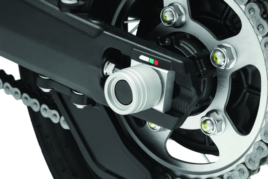 Kuryakyn rear axle slide for Honda CRF1000L Africa Twin and Adventure Sports motorcycle, part #3827, shown on a motorcycle wheel.