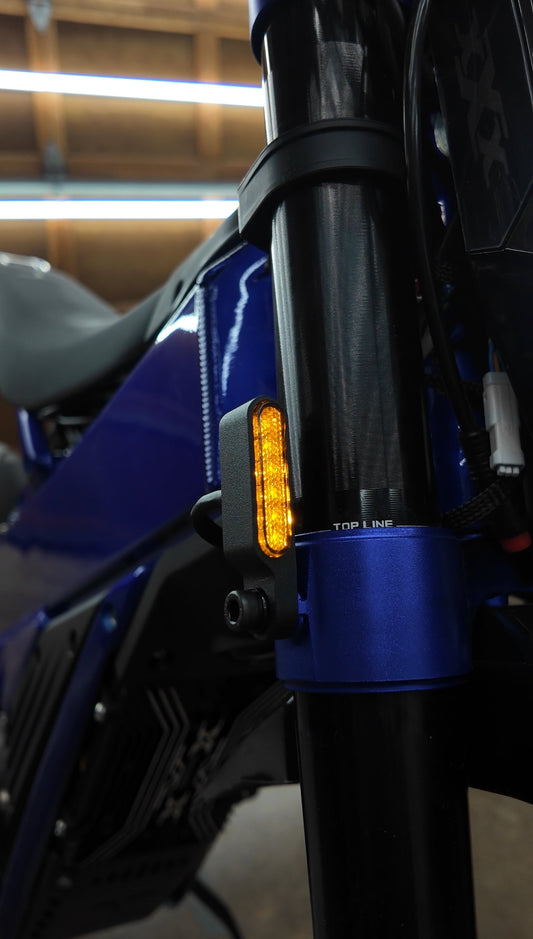 Project 9 Surron Talaria E-Ride Pro LED turn signal and brake light kit installed on stock forks, showcasing sleek motorcycle lighting.