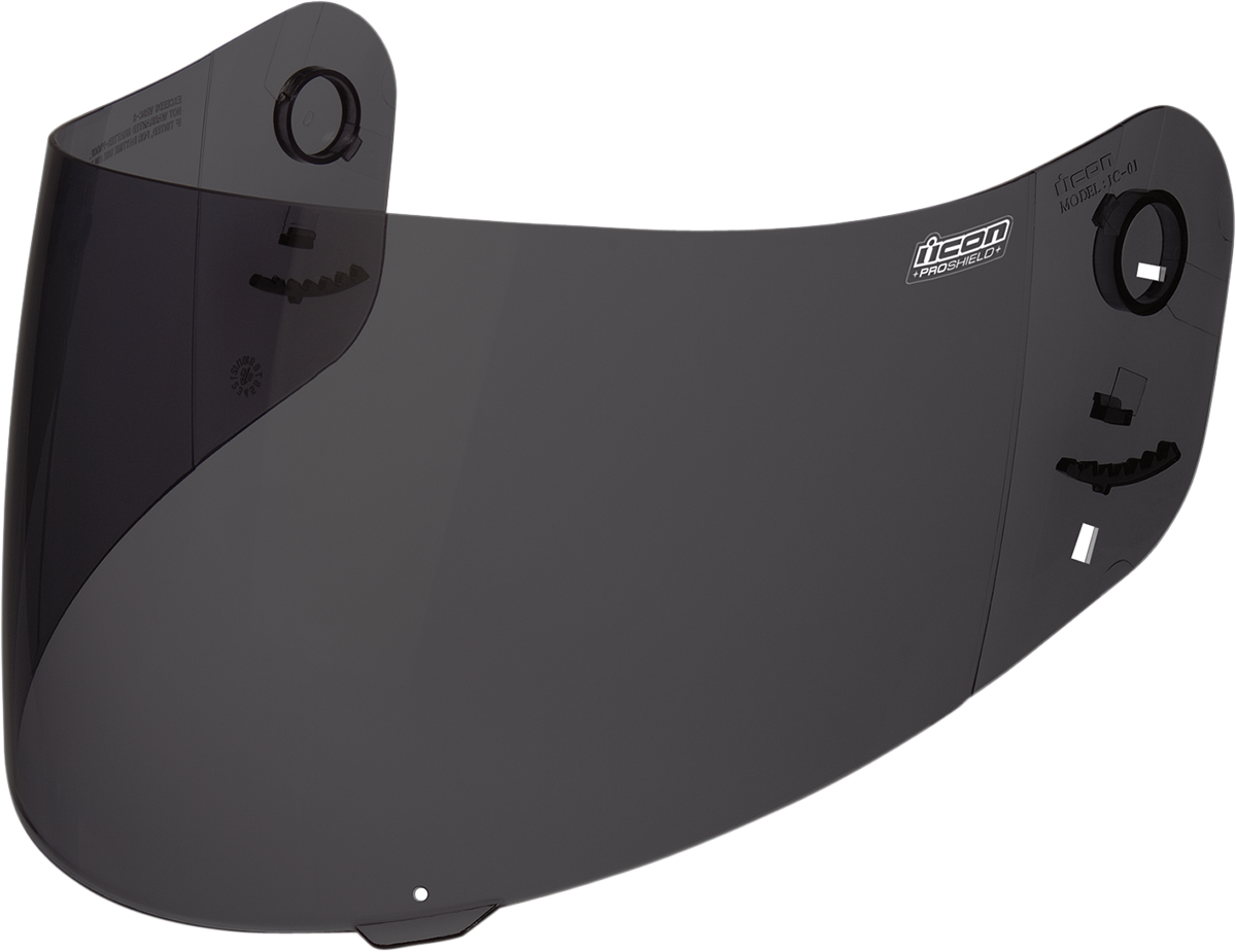 Dark smoke ICON Proshield™ helmet face shield for helmets parts by Bill’s Exhausts, showing tinted shield with reflective finish.