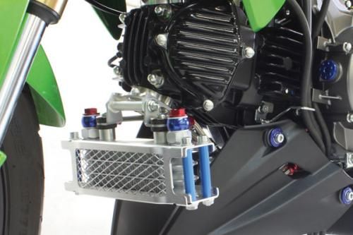 SP Takegawa compact oil cooler kit with filter adaptor, featuring metal fins and hoses for efficient engine oil cooling.