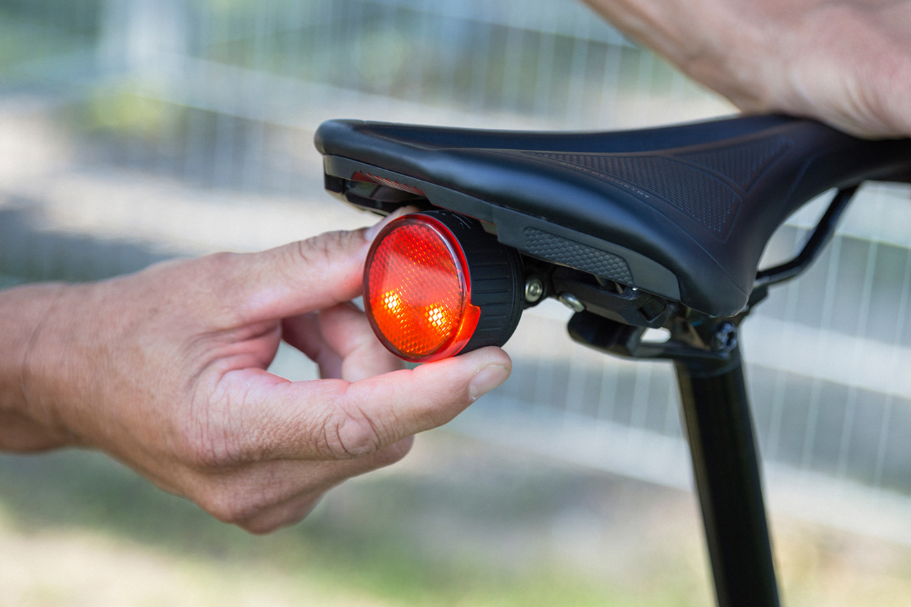 Red SP CONNECT All-Round LED Safety Light attached to a phone, emitting 100 lumens for visibility and safety.