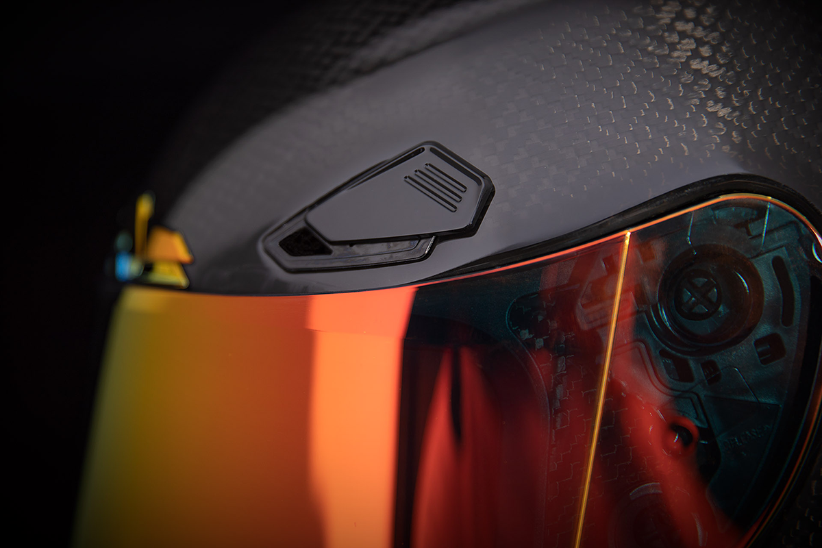 Red ICON Airframe Pro™ helmet in small size with carbon shell, shown from the side, featuring aerodynamic design and branding details.