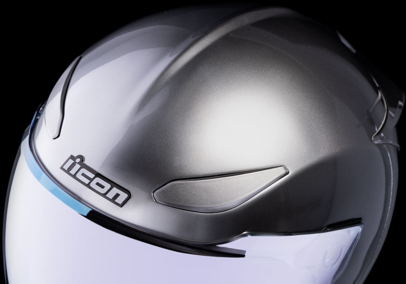 Icon Domain Cornelius helmet in silver, large size, with aerodynamic design and secure chin strap, showcasing the sleek helmet profile.