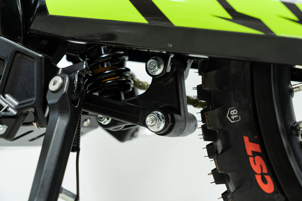 Howling Moto Grasshopper SE electric dirt bike with 72V 60Ah battery and 12.5kW mid-drive motor, shown outdoors on rugged terrain.