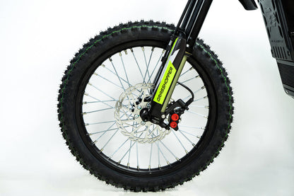 Howling Moto Grasshopper SE electric dirt bike with 72V 60Ah battery and 12.5kW mid-drive motor, shown on rugged terrain.
