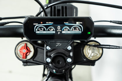 Howling Moto Grasshopper SE electric dirt bike with 72V 60Ah battery and 12.5kW mid-drive, shown outdoors on rugged terrain.
