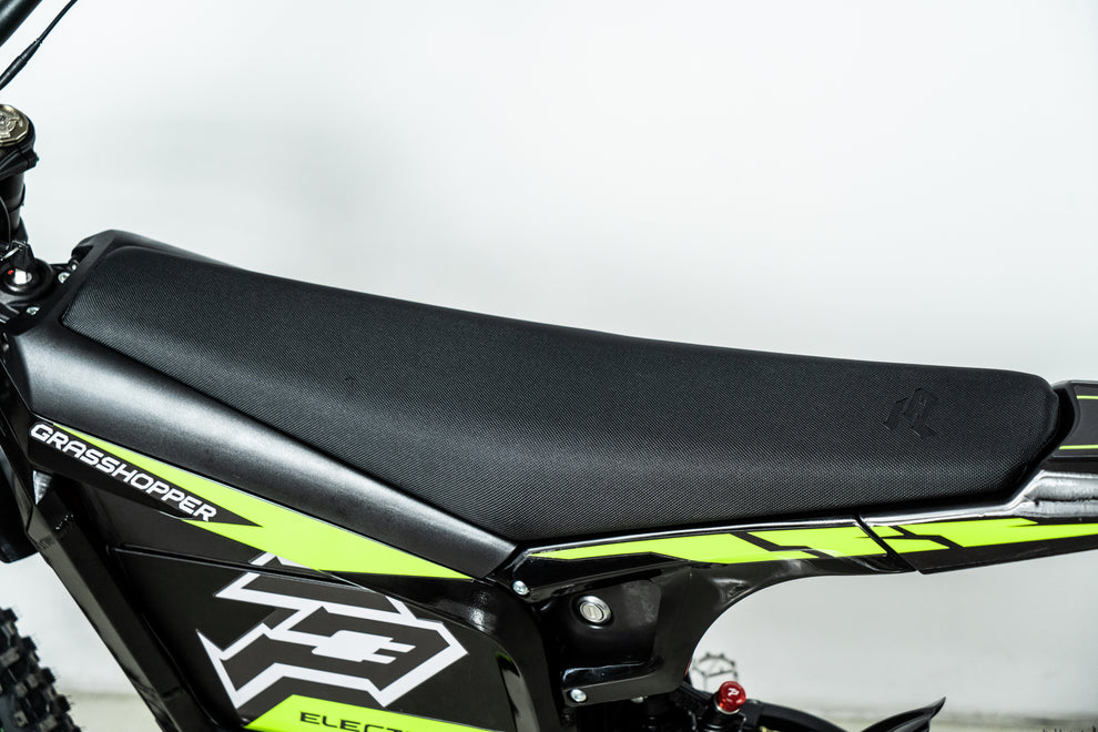 Howling Moto Grasshopper SE electric dirt bike with 72V 60Ah battery and 12.5kW mid-drive, shown in a dynamic outdoor setting.