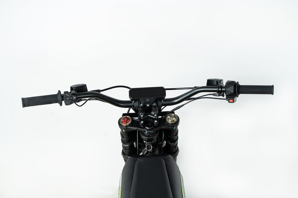 Howling Moto Grasshopper SE electric dirt bike with 72V 60Ah battery and 12.5kW mid-drive motor, shown on rugged terrain.