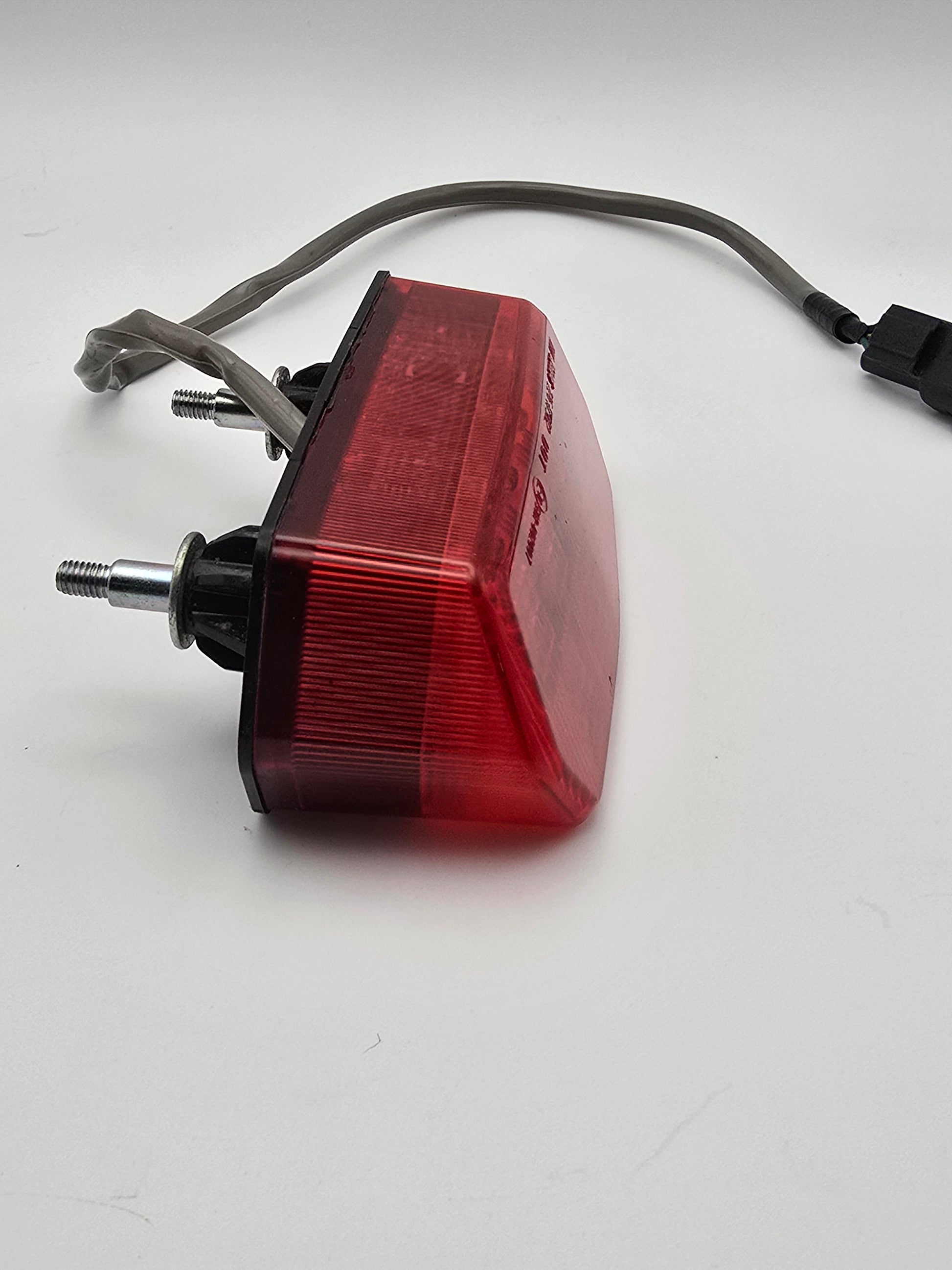 Used Honda Grom OEM tail light for 2014-2015 models, motorcycle lighting part with red lens and wiring.
