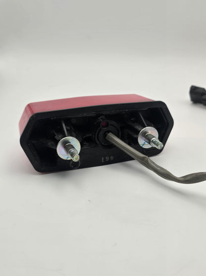 Used Honda Grom OEM tail light for 2014-2015 models, motorcycle lighting part with clear lens and red brake light.