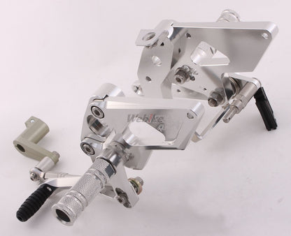 Over Racing rearsets with 4-position adjustability for Honda Grom motorcycle, showing black metal footpeg and mounting hardware.