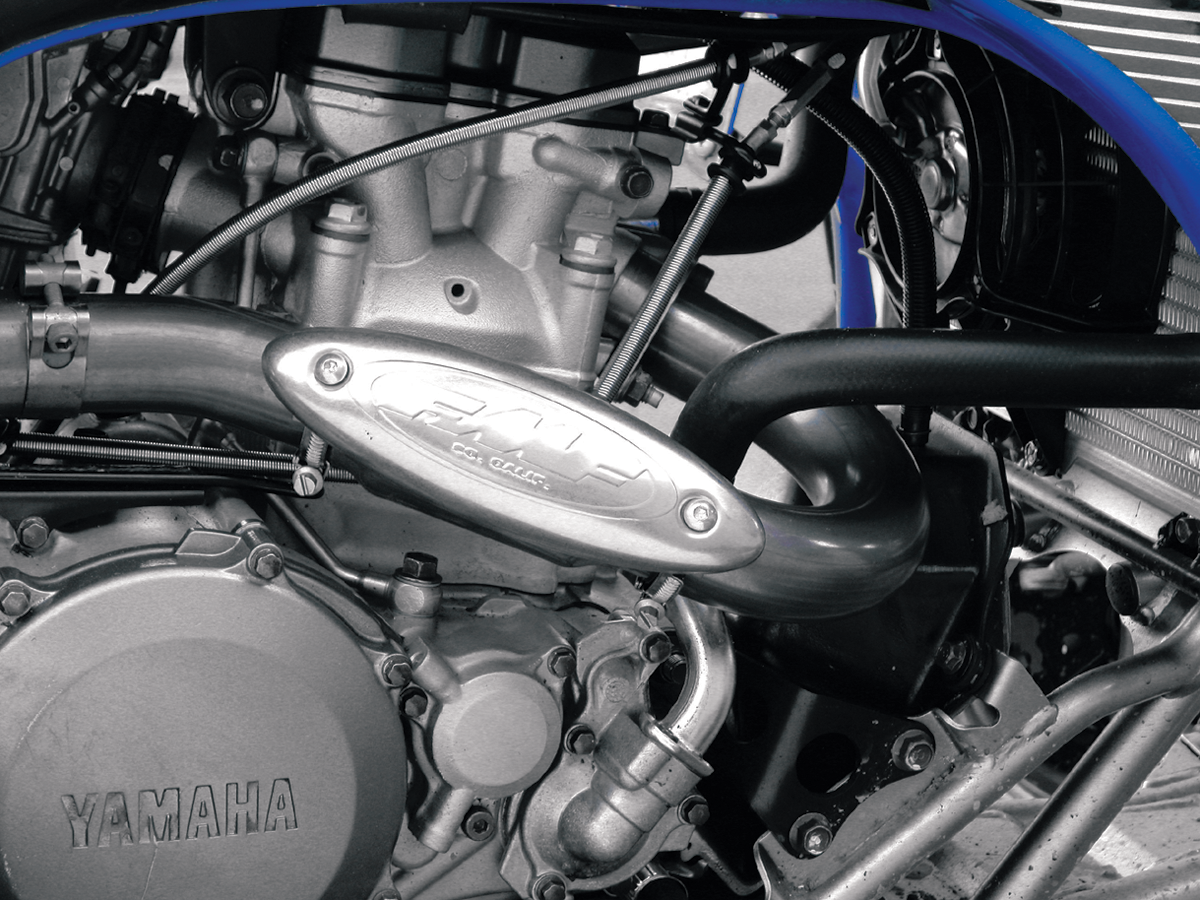 Stainless steel FMF Universal Header Heat Shield installed on motorcycle exhaust header, providing heat protection.