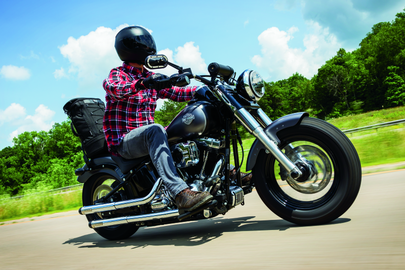 Kuryakyn satin black front axle nut caps installed on a Harley Davidson Touring motorcycle wheel for a sleek, finished look.