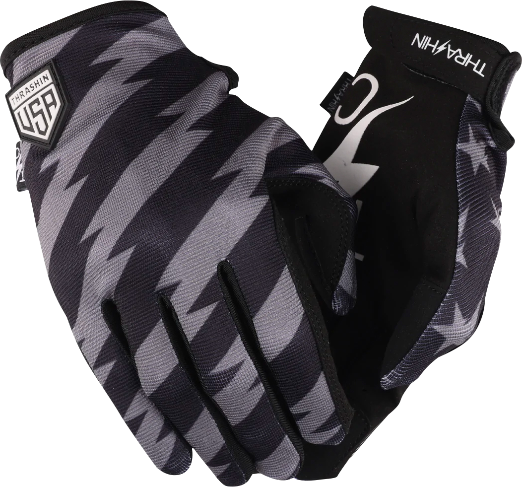 Black and gray THRASHIN SUPPLY CO. Stars & Bolts Stealth Gloves in large size, showcasing durable comfort and sleek design.