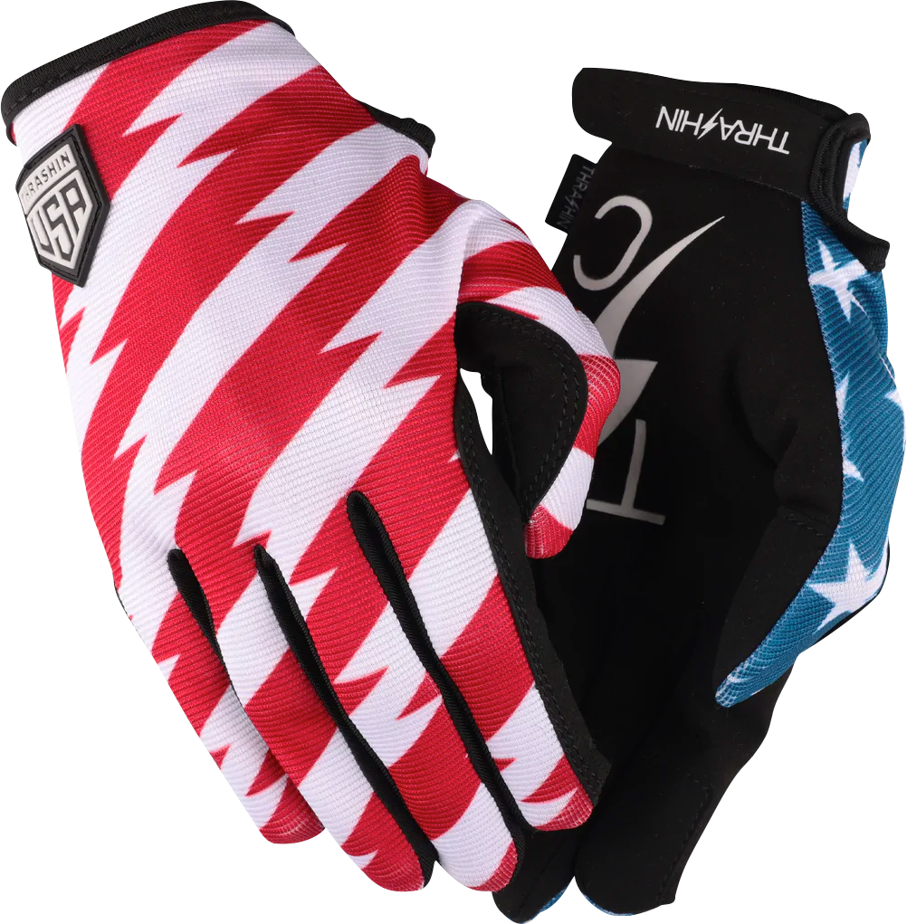 Red and blue Stealth Gloves by THRASHIN SUPPLY CO. with stars and bolts design, medium size, showcasing the durable fabric and detailed patterns.