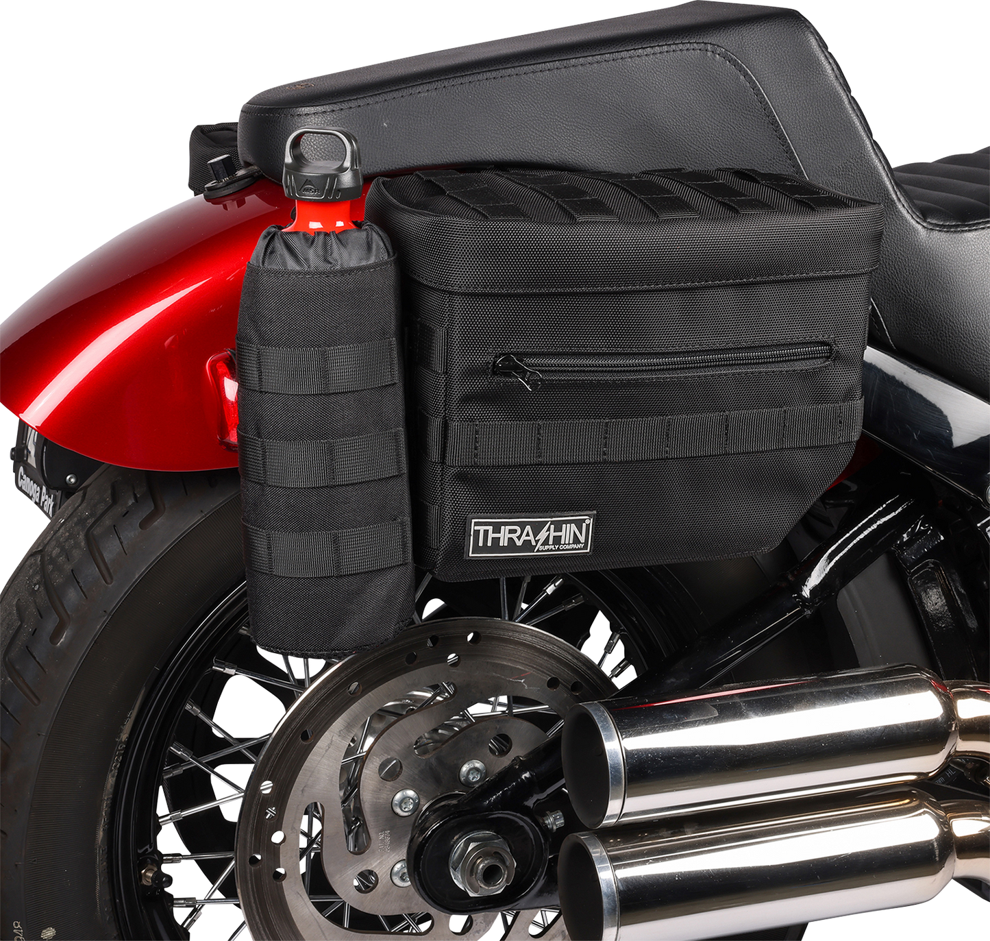 Black THRASHIN SUPPLY CO. Essential Saddlebags TSB-0006 with 10-liter capacity, shown mounted on a motorcycle for storage.
