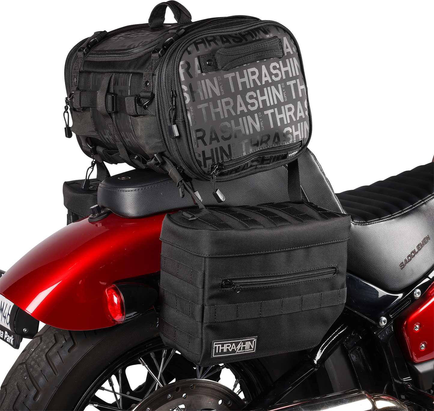 Black THRASHIN SUPPLY CO. Essential Saddlebags TSB-0006 with 10-liter storage capacity, mounted on a motorcycle for touring.