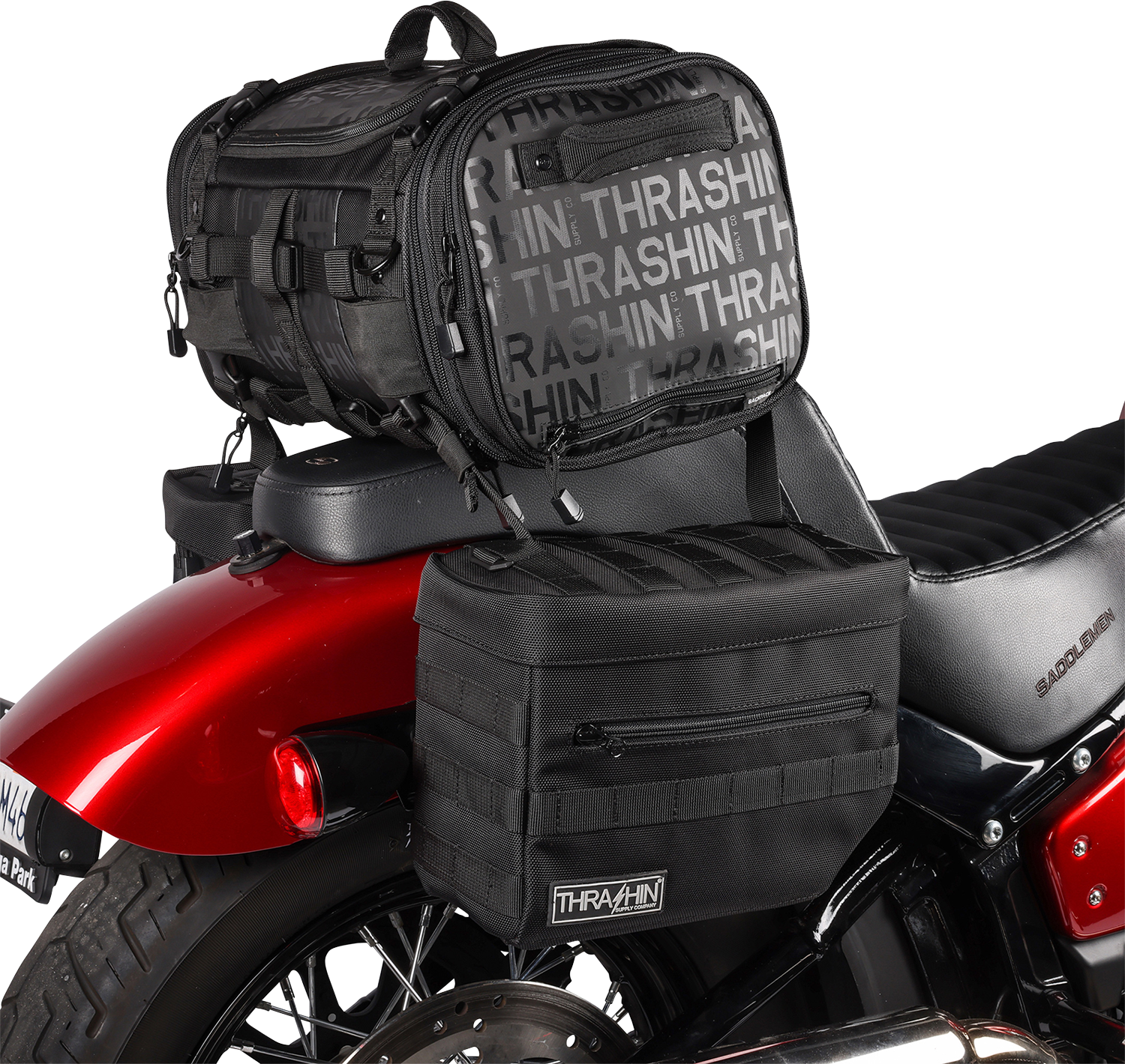 Black THRASHIN SUPPLY CO. Essential Saddlebags TSB-0006 with 10-liter storage capacity, mounted on a motorcycle for touring.