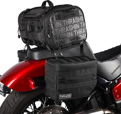 Black THRASHIN SUPPLY CO. Essential Saddlebags TSB-0006 with 10-liter storage capacity, mounted on a motorcycle for touring.
