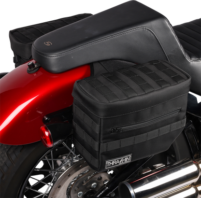 Black THRASHIN SUPPLY CO. Essential Saddlebags TSB-0006 with 10-liter capacity, shown mounted on a motorcycle for storage.