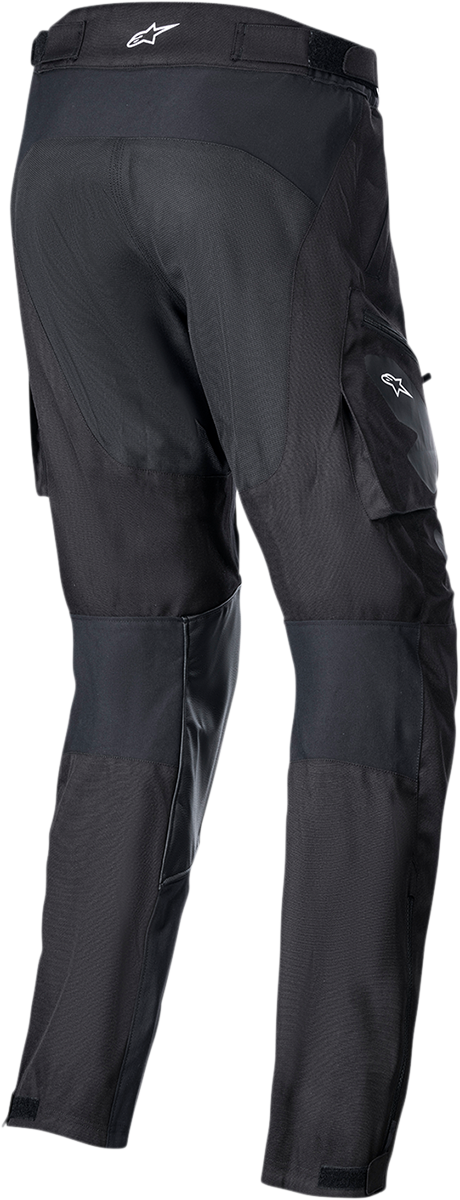 Black ALPINESTARS Venture XT over-the-boot motorcycle pants, medium size, with reinforced areas and adjustable straps.