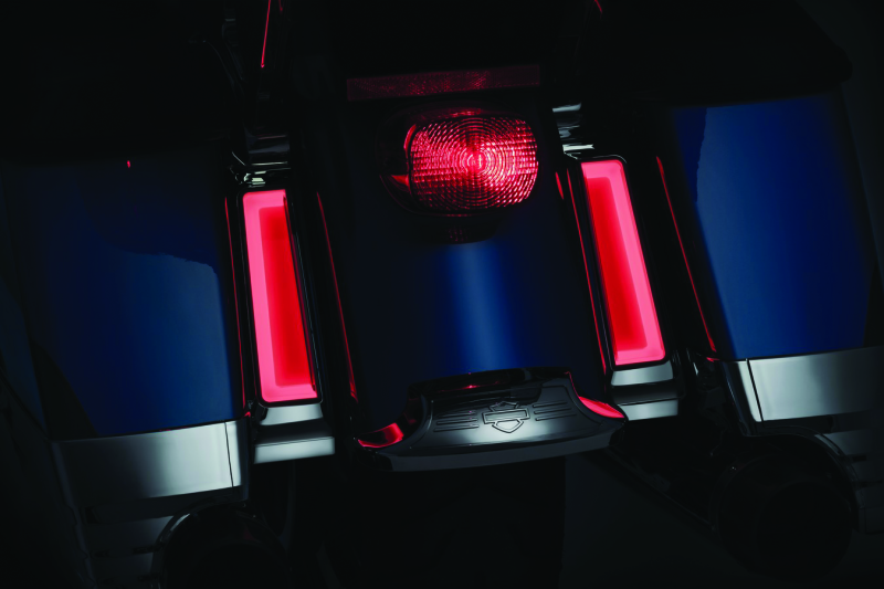 Kuryakyn Tracer LED inserts for saddlebag supports in chrome, showing red auxiliary lighting on Harley Davidson touring motorcycle