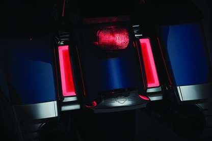 Kuryakyn Tracer LED inserts for saddlebag supports in chrome, showing red auxiliary lighting on Harley Davidson touring motorcycle