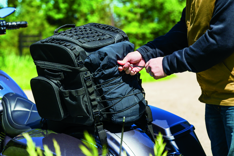 Kuryakyn Momentum Vagabond Bag mounted on motorcycle seat and luggage rack for versatile storage.