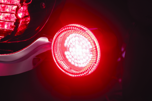 Kuryakyn Luminez LED rear turn signal insert in red for Harley-Davidson 1156, showing the bright LED light and red housing.