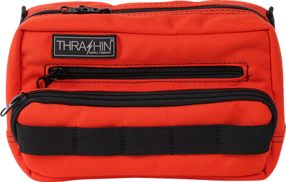 Orange THRASHIN SUPPLY CO. Handlebar Bag Plus mounted on a bicycle handlebar, showing its compact, durable design.