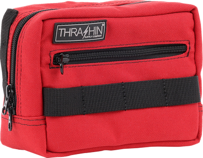 Red THRASHIN SUPPLY CO. handlebar bag with adjustable straps and zip closure, mounted on a bicycle handlebar.