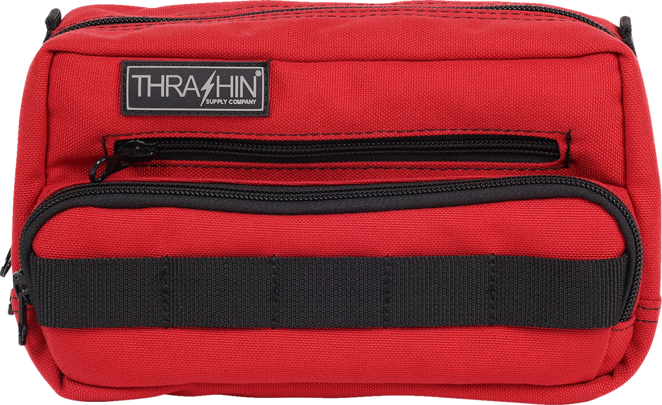 Red THRASHIN SUPPLY CO. Handlebar Bag Plus mounted on a bicycle handlebar, showing its compact design and adjustable straps.