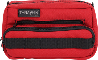 Red THRASHIN SUPPLY CO. Handlebar Bag Plus mounted on a bicycle handlebar, showing its compact design and adjustable straps.