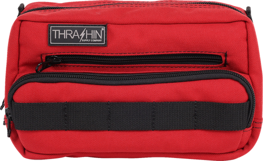 Red THRASHIN SUPPLY CO. Handlebar Bag Plus mounted on a bicycle handlebar, showing its compact design and adjustable straps.