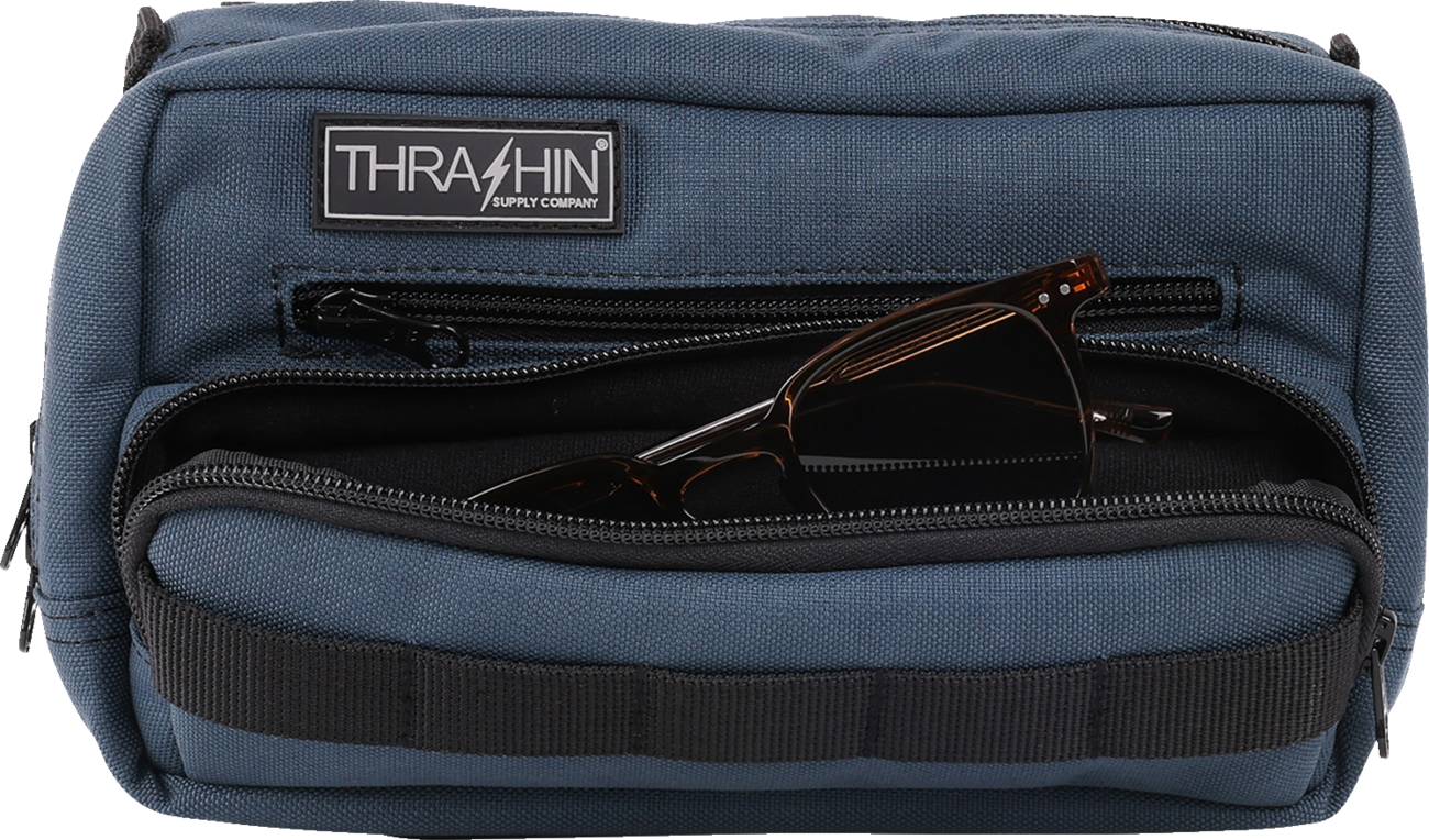 Blue THRASHIN SUPPLY CO. Handlebar Bag Plus mounted on a bicycle handlebar, showcasing its compact design and secure attachment.